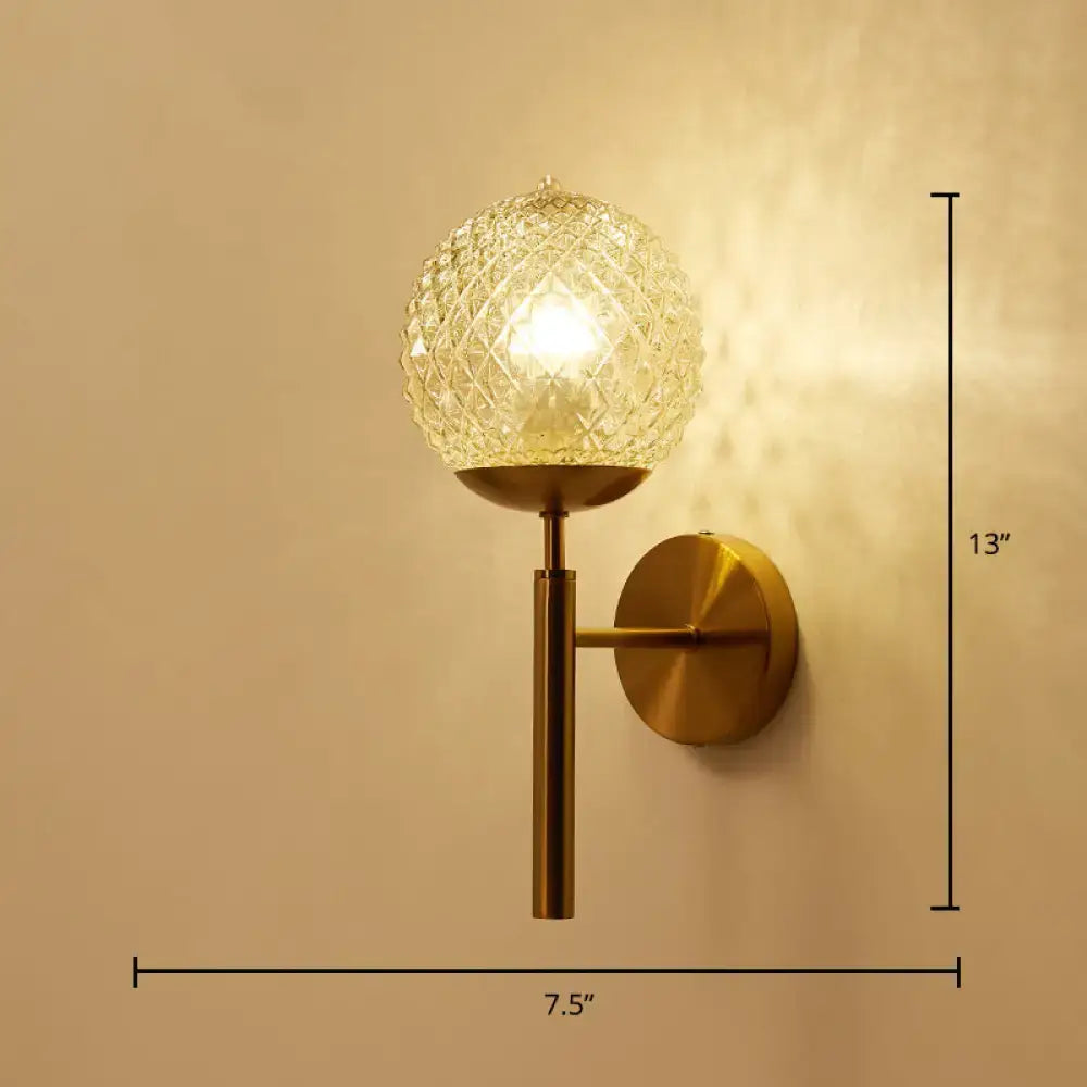 Postmodern gold ball shaped wall sconce featuring a textured glass shade with faceted crystal globe for bedroom lighting