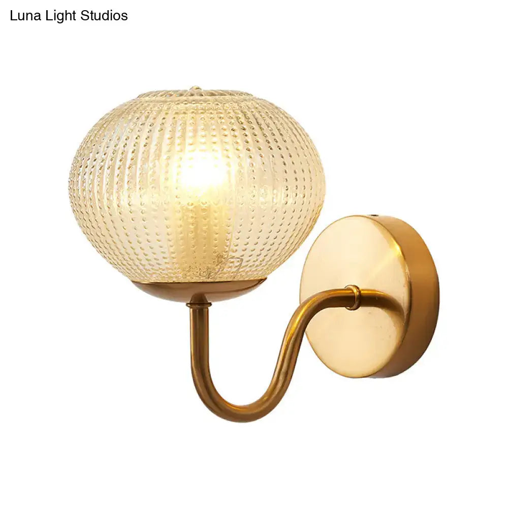 Postmodern gold ball shaped wall sconce with warm brass finish and textured glass shade for bedroom lighting