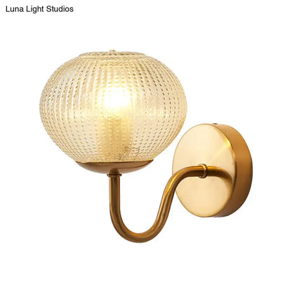 Postmodern gold ball shaped wall sconce with warm brass finish and textured glass shade for bedroom lighting