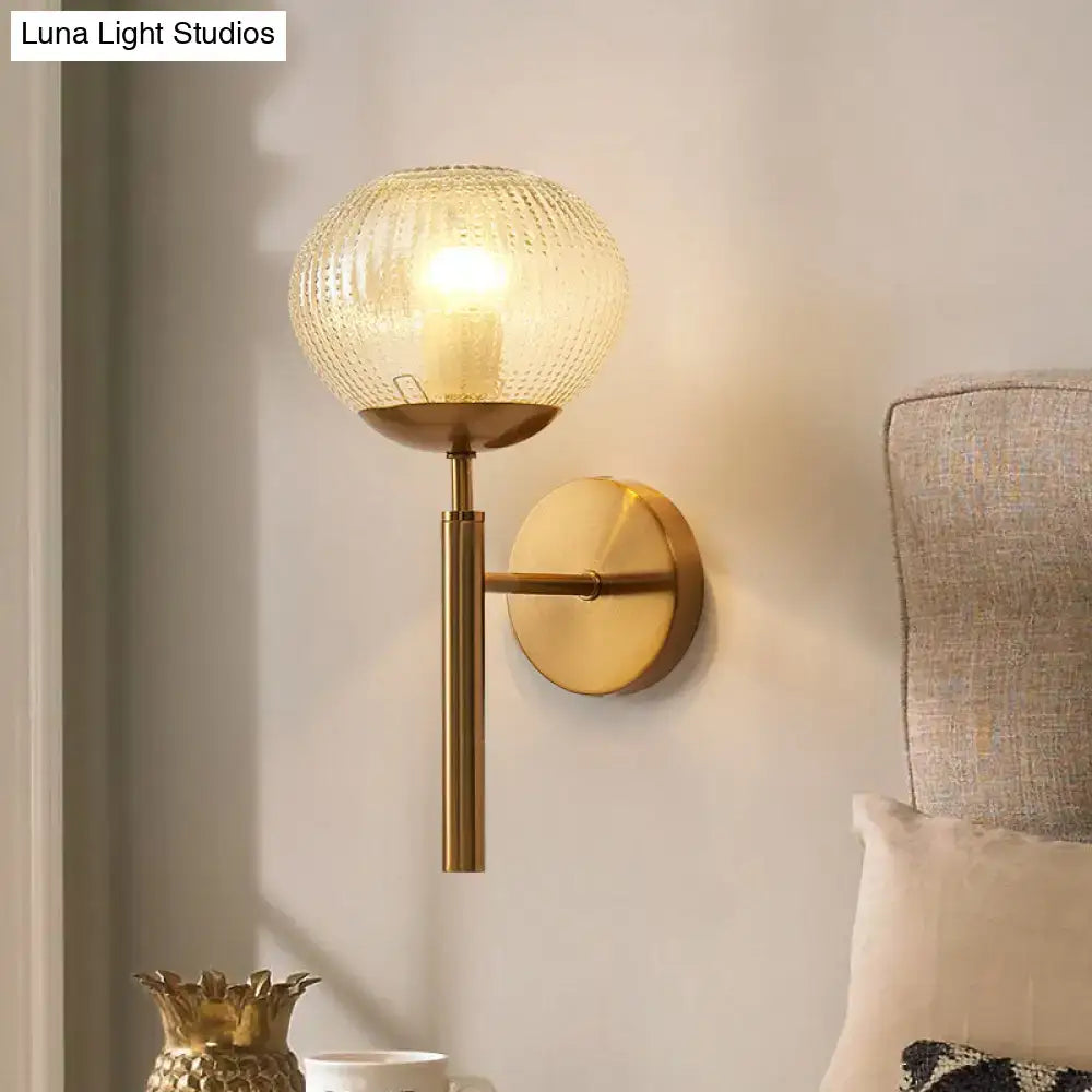 Postmodern gold wall sconce with textured glass shade and ball shaped amber glass globe for bedroom lighting