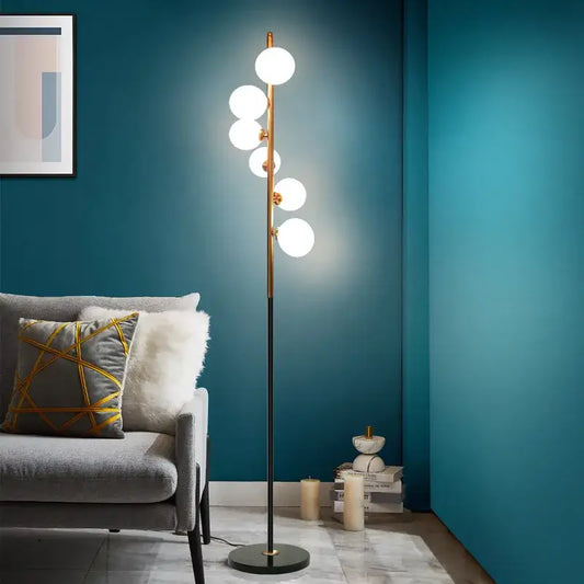 Postmodern gold and black glass floor lamp with five glowing white spherical bulbs in elegant vertical cascade for living room