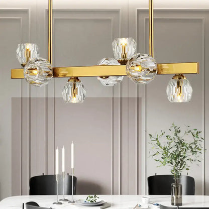 Gold-toned pendant light with clear faceted crystal globe shades featuring gold branch design for island lighting