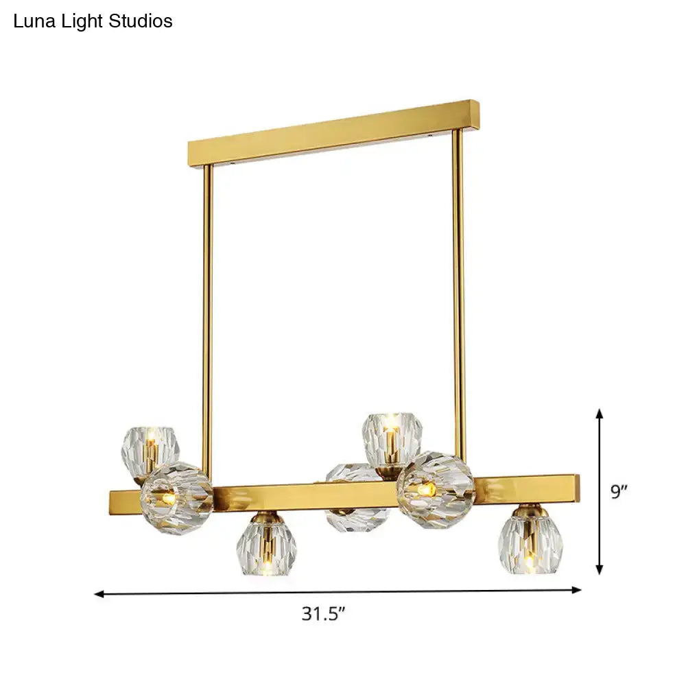 Gold-finished modern pendant light with clear crystal globe shades featuring a gold branch design for island lighting