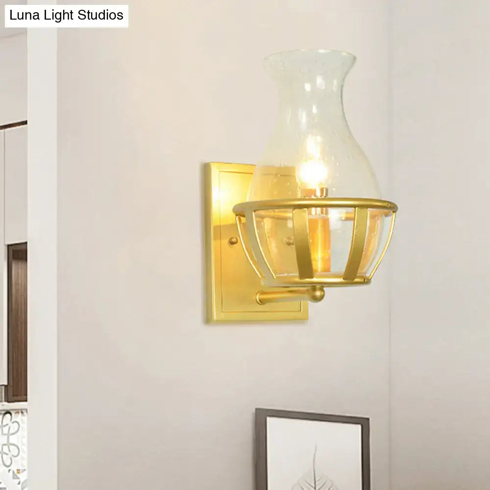 Postmodern gold wall lamp with clear glass vase-shaped shade and metal frame sconce for living room use