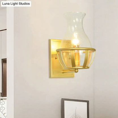 Postmodern gold wall lamp with clear glass vase-shaped shade and metal frame sconce for living room use