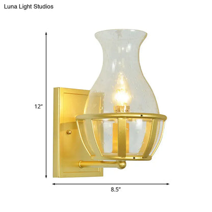 Postmodern gold wall lamp with clear glass shade and metal frame featuring brass cage detailing for living room use