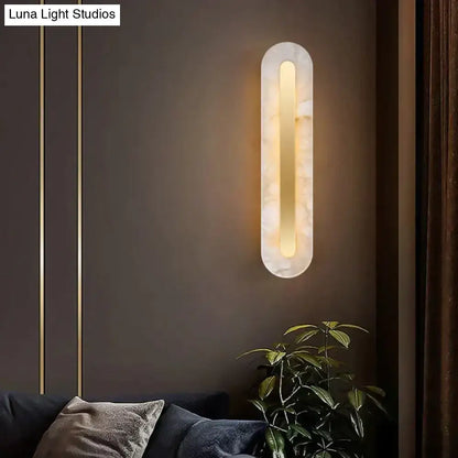 A sleek postmodern gold copper marble wall lamp with warm amber glow for living room lighting