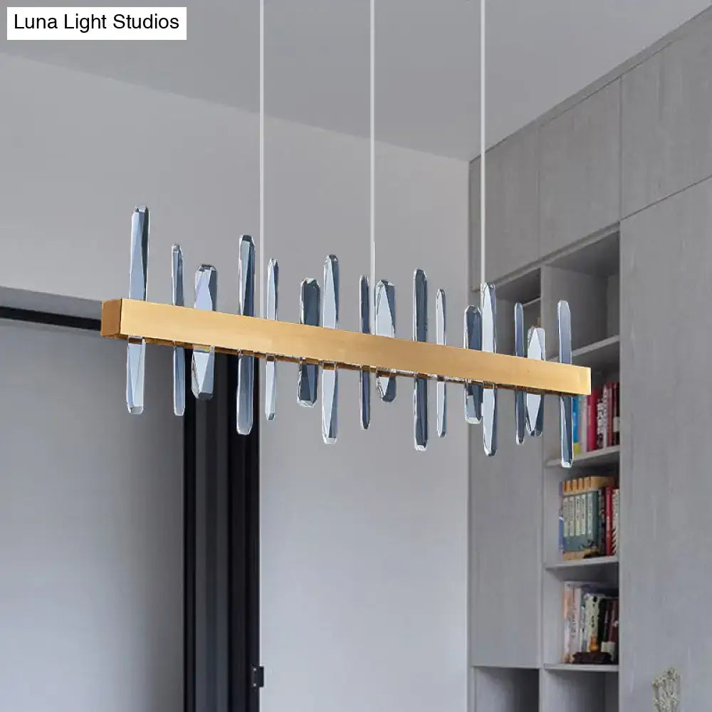 Modern gold-toned rectangular linear hanging island chandelier with clear faceted crystal pendant elements for dining room