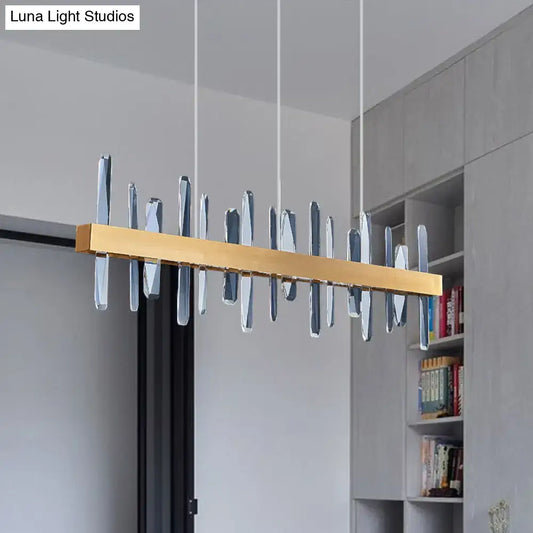 Modern gold-toned rectangular linear hanging island chandelier with clear faceted crystal pendant elements for dining room