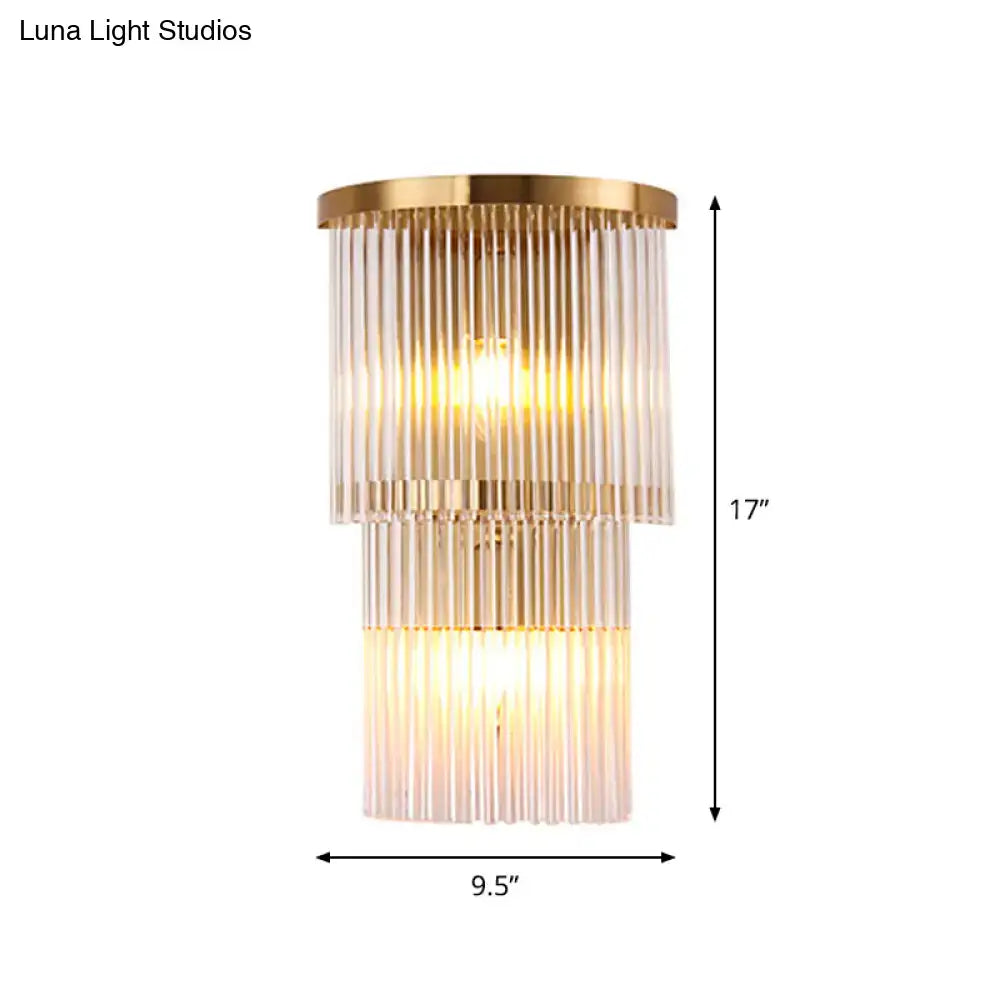 Gold-toned postmodern wall light with tiered ribbed glass panels for chic bedroom or living space lighting