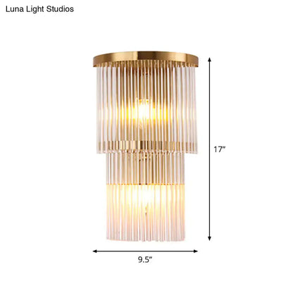 Gold-toned postmodern wall light with tiered ribbed glass panels for chic bedroom or living space lighting