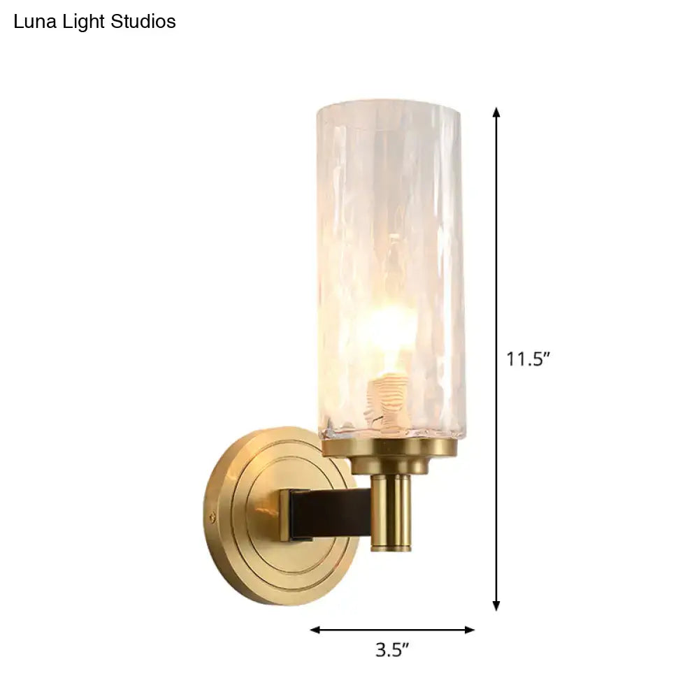 Postmodern gold crystal wall mounted light featuring brass finish and textured translucent cylindrical glass shade for living room