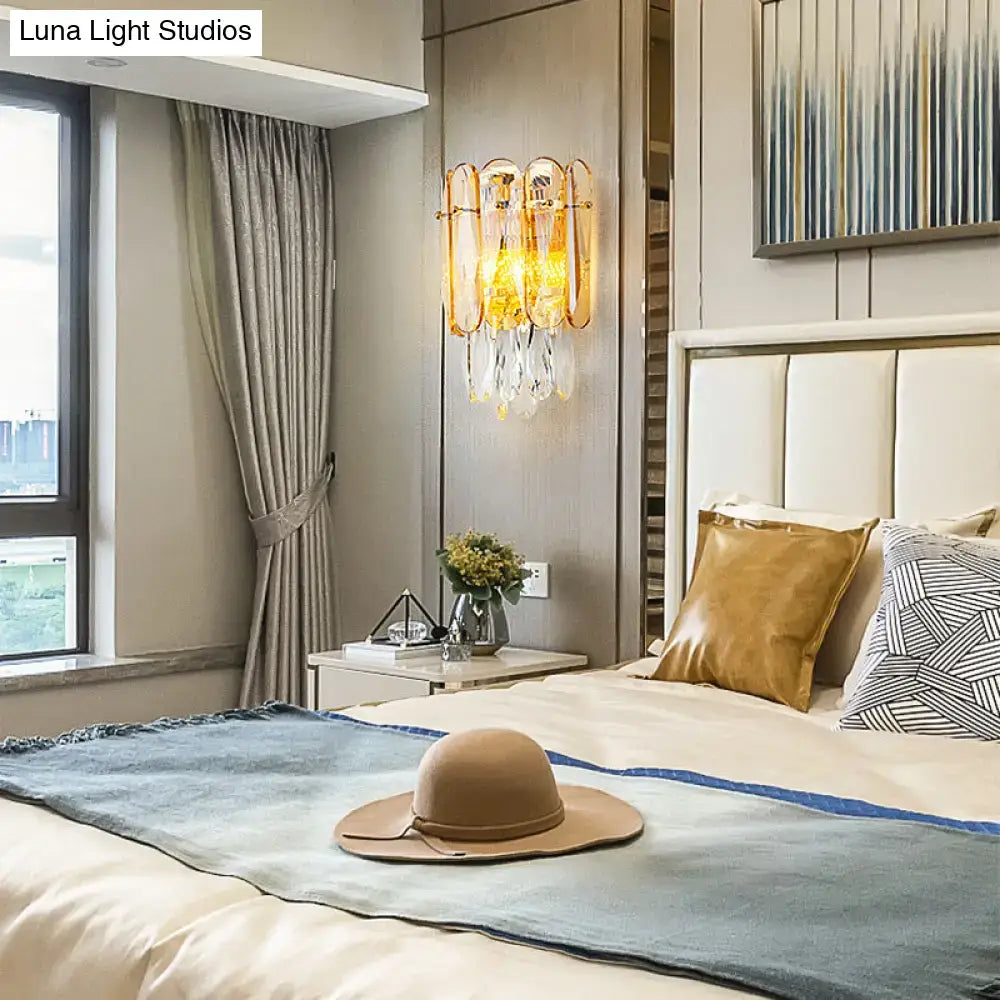 Beige wide-brimmed hat resting on bed near postmodern gold faceted crystal sconce light for bedroom wall light