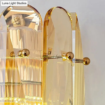 Postmodern gold faceted crystal sconce light with golden acrylic ribbed panels and brass accents for bedroom wall light