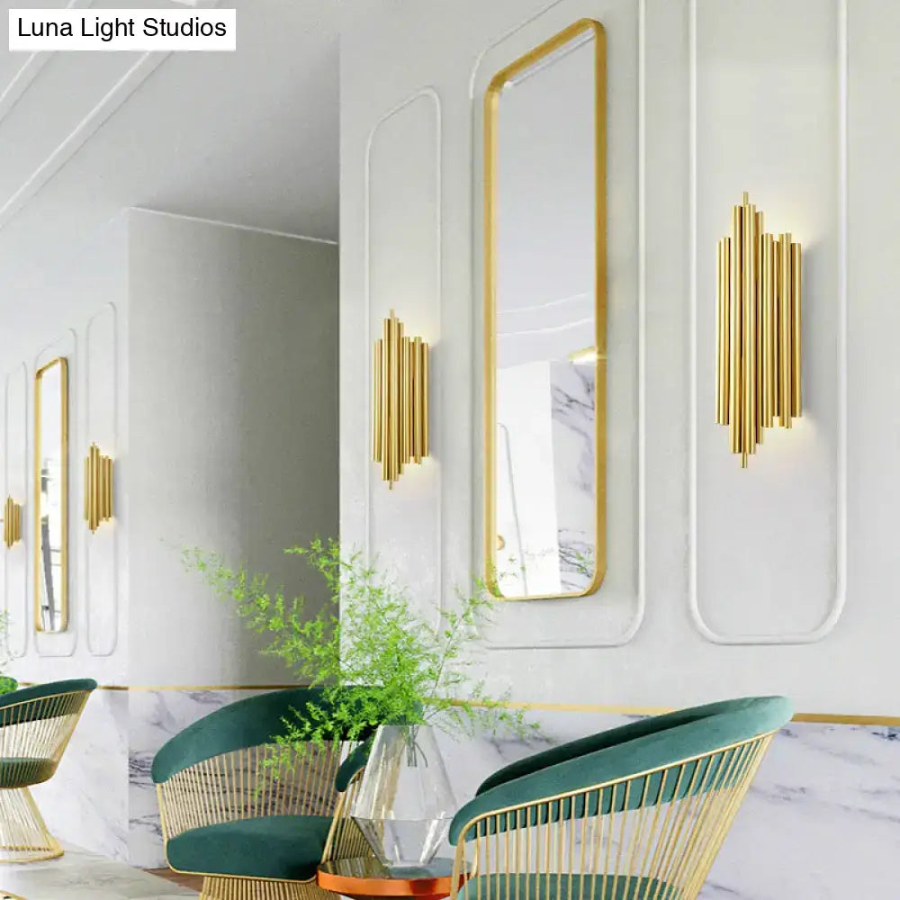 Gold finish flute wall mount sconce with a gold-toned vertical bar and modern minimalist design for living room use