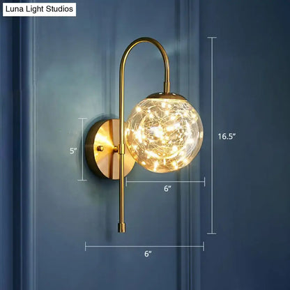 Postmodern gold-toned glass globe wall light fixture with warm glowing fairy lights for bedroom ambiance