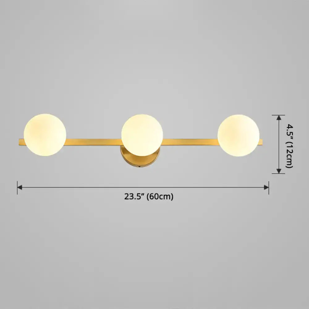 Postmodern gold-toned wall sconce with three frosted glass globe shades and fixture height 11in with bulb base