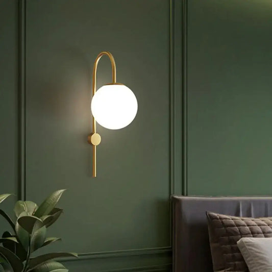 Postmodern gold wall lamp with gooseneck arm and cream glass globe for bedroom lighting decor