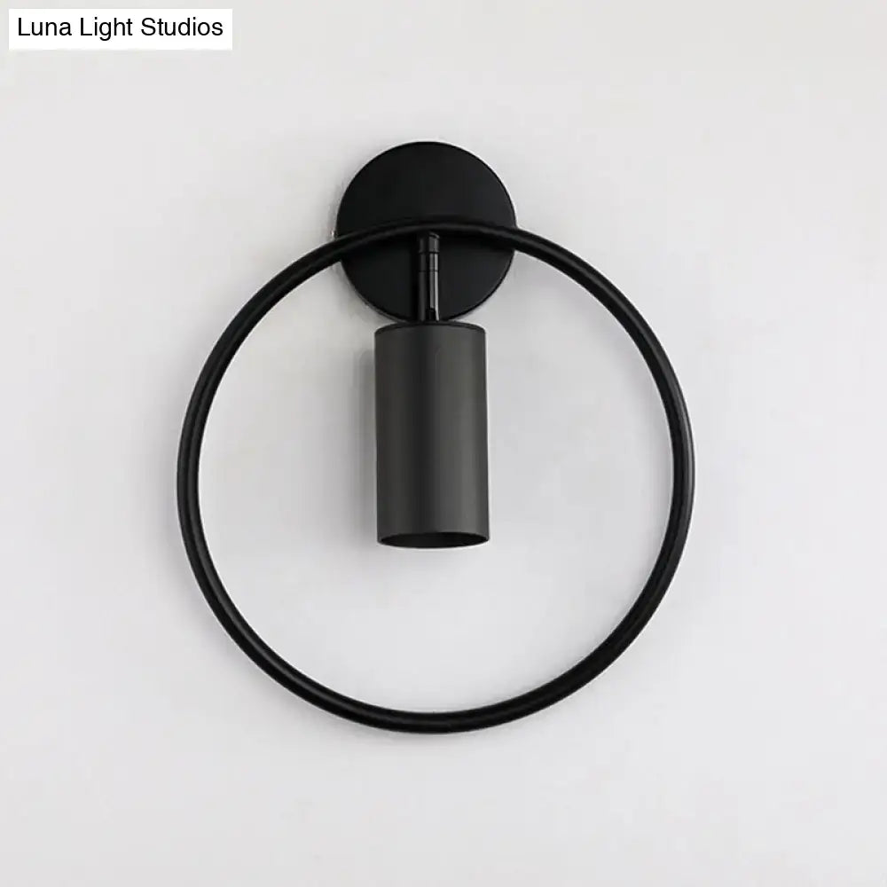 Black minimalist wall sconce with a gold halo ring and cylindrical light fixture 16 inches fixture height