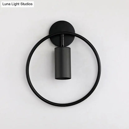 Black minimalist wall sconce with a gold halo ring and cylindrical light fixture 16 inches fixture height