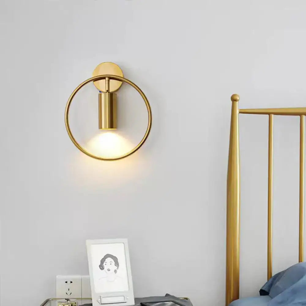 Postmodern gold-toned circular wall sconce with minimalist cylindrical light fixture and 16 inches fixture height for bedroom