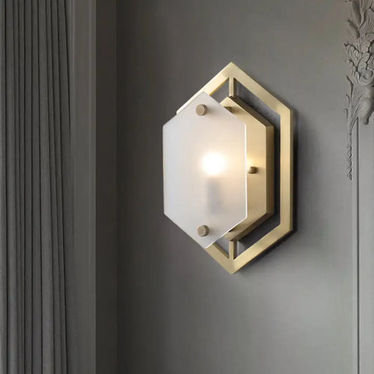 Gold-toned hexagonal wall lamp with frosted glass shade for modern bedroom sconce lighting installation