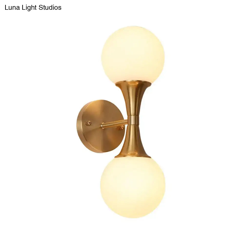 Brass-finished wall lamp with two frosted milk glass globe shades postmodern sconce light for living room use