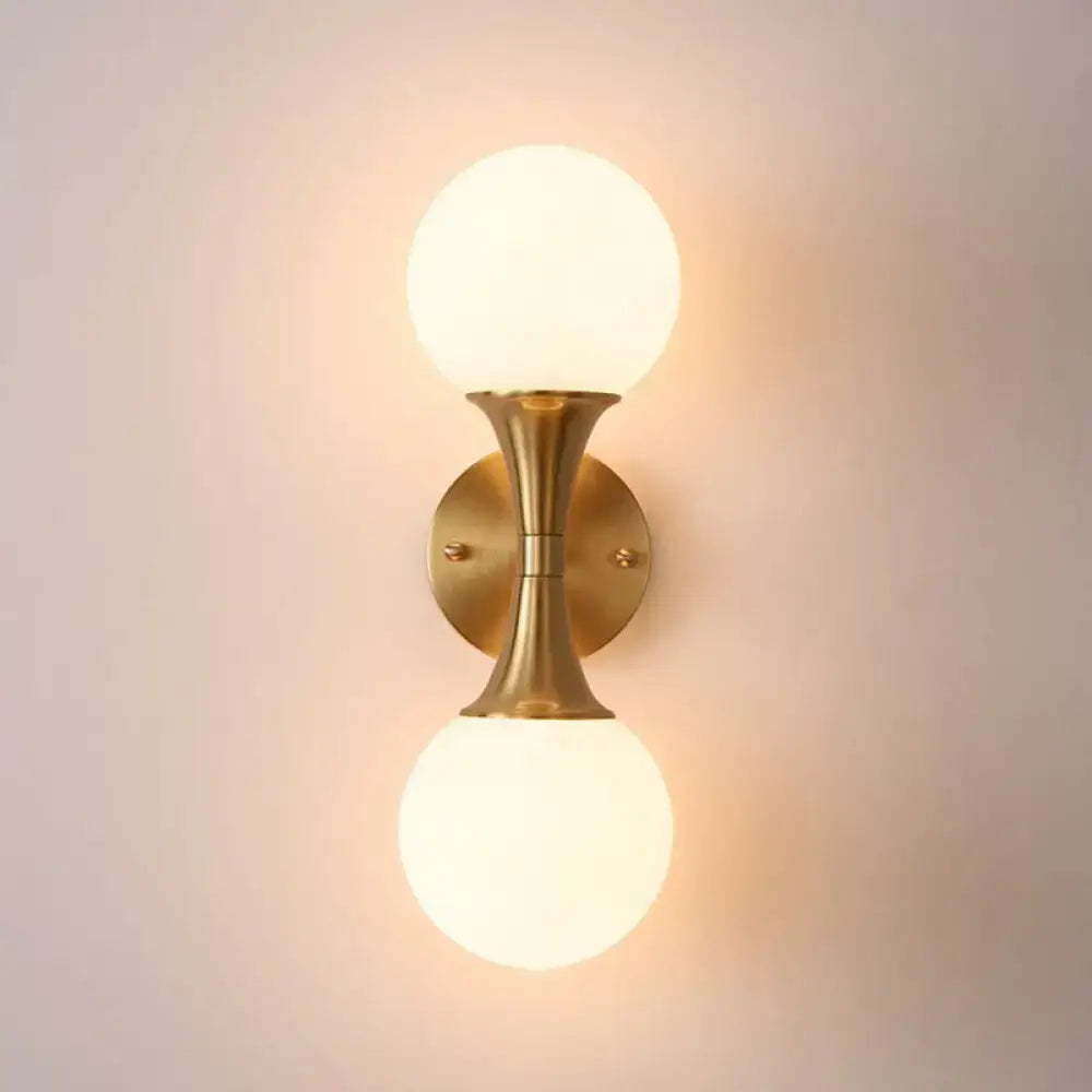Brass-finished wall lamp with two frosted milk glass globe shades postmodern sconce light for living room