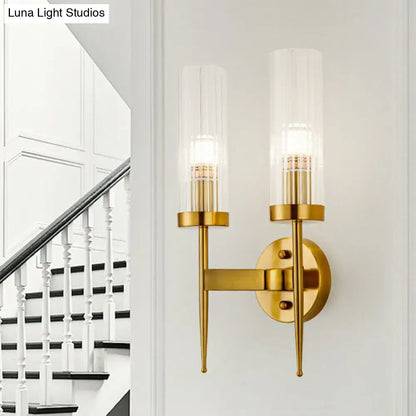 Postmodern gold-toned wall sconce with clear ribbed glass cylindrical shades and slender metallic arms for stairway lighting
