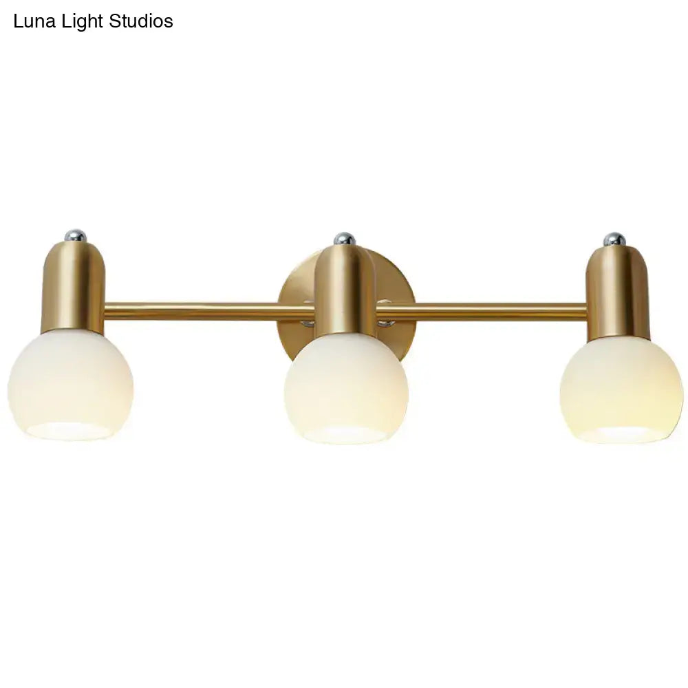 Postmodern gold swivel dome milk glass vanity light featuring three frosted glass globe bulbs for bathroom use