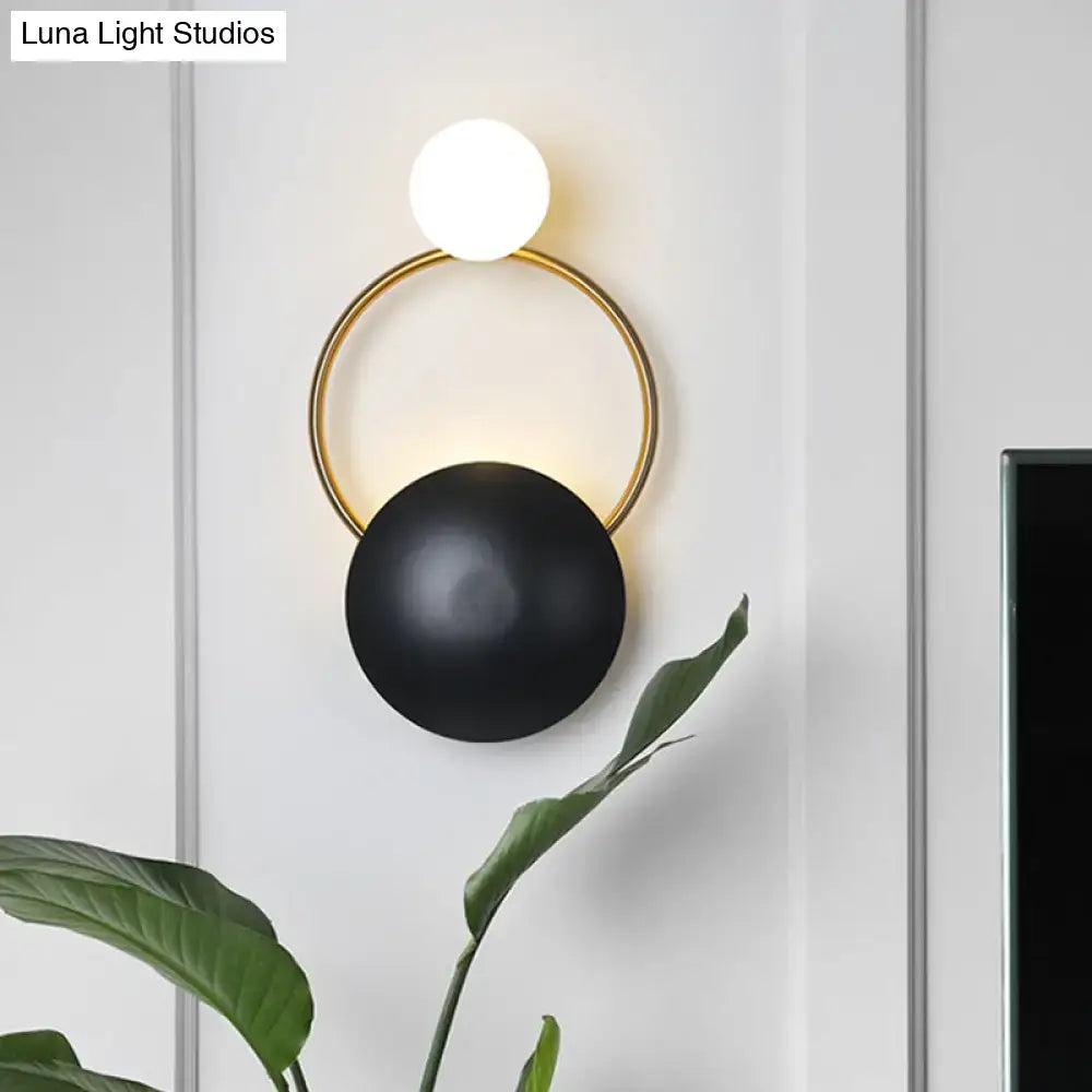 Postmodern orbital flush mount wall sconce with gold-toned frame and black matte sphere for bedroom lighting