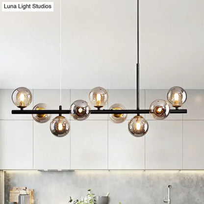 Modern black metal chandelier with multiple amber-tinted glass globes in smoke grey cognac for dining room lighting