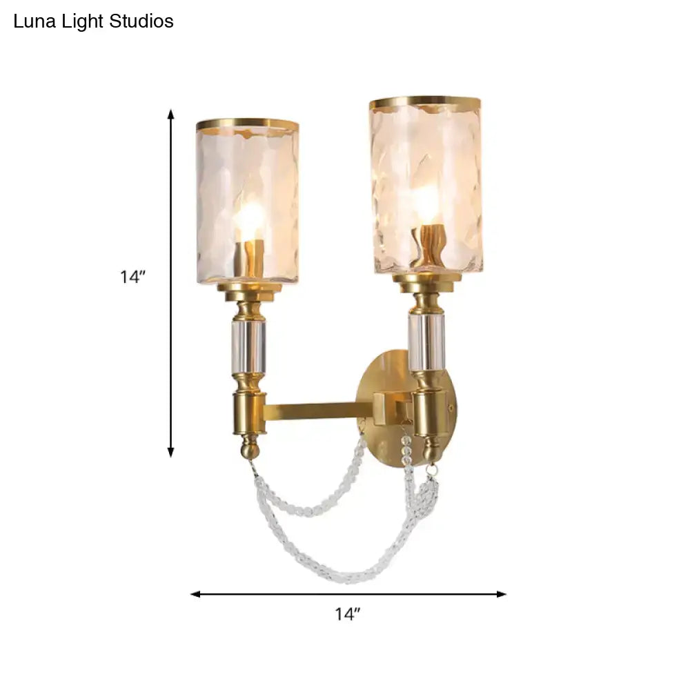 Postmodern water glass brass wall light with gold-toned sconce, two textured glass shades, and crystal chain detail