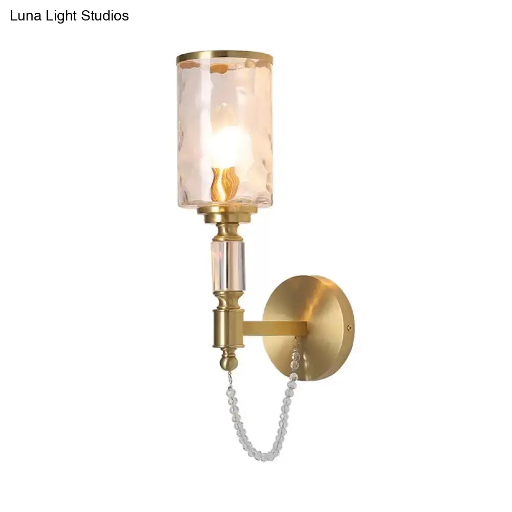 Postmodern water glass brass wall light featuring a gold finish, textured translucent glass shade, and crystal beads