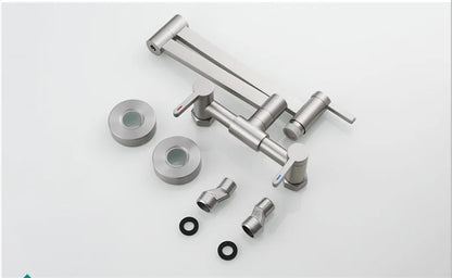 Stainless steel surgical instrument set with articulated arms alongside a wall mounted single hole brushed gold pot filler tap