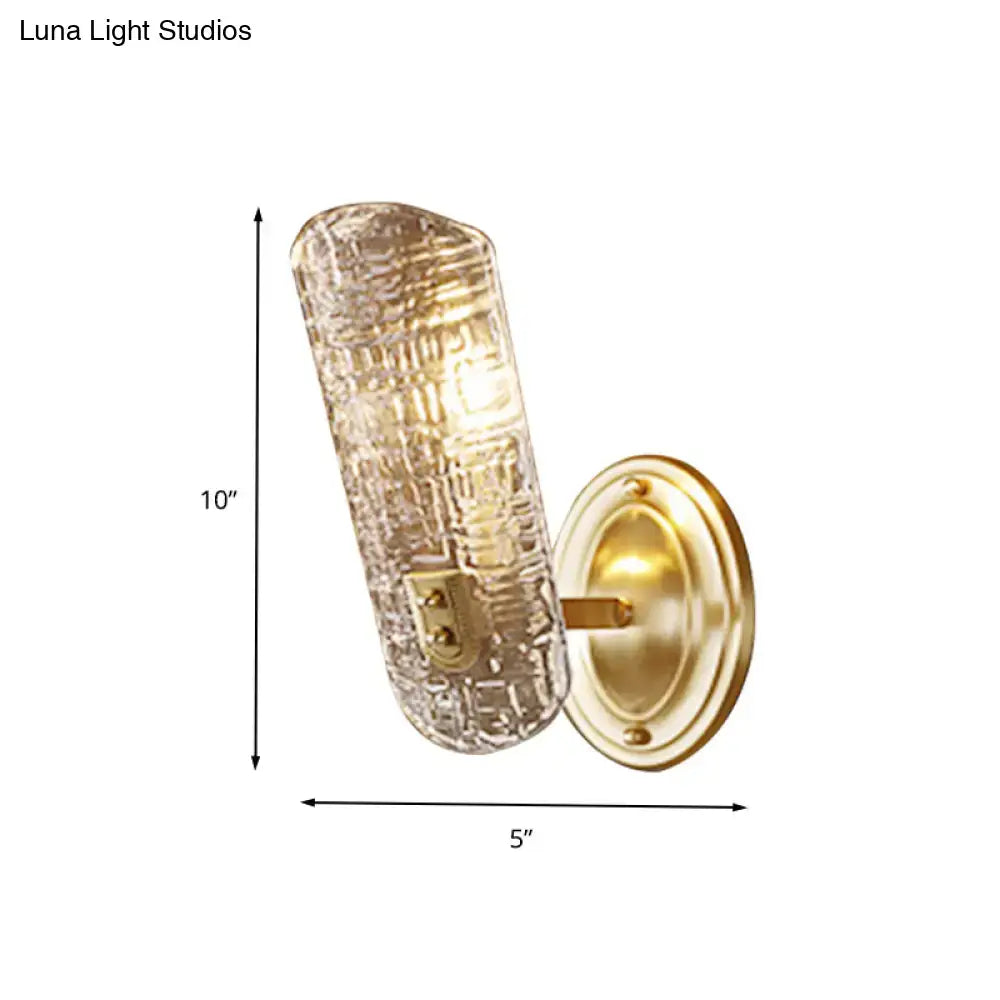 A 10-inch prism textured glass wall light with a gold-finished metal base for corridor mounting
