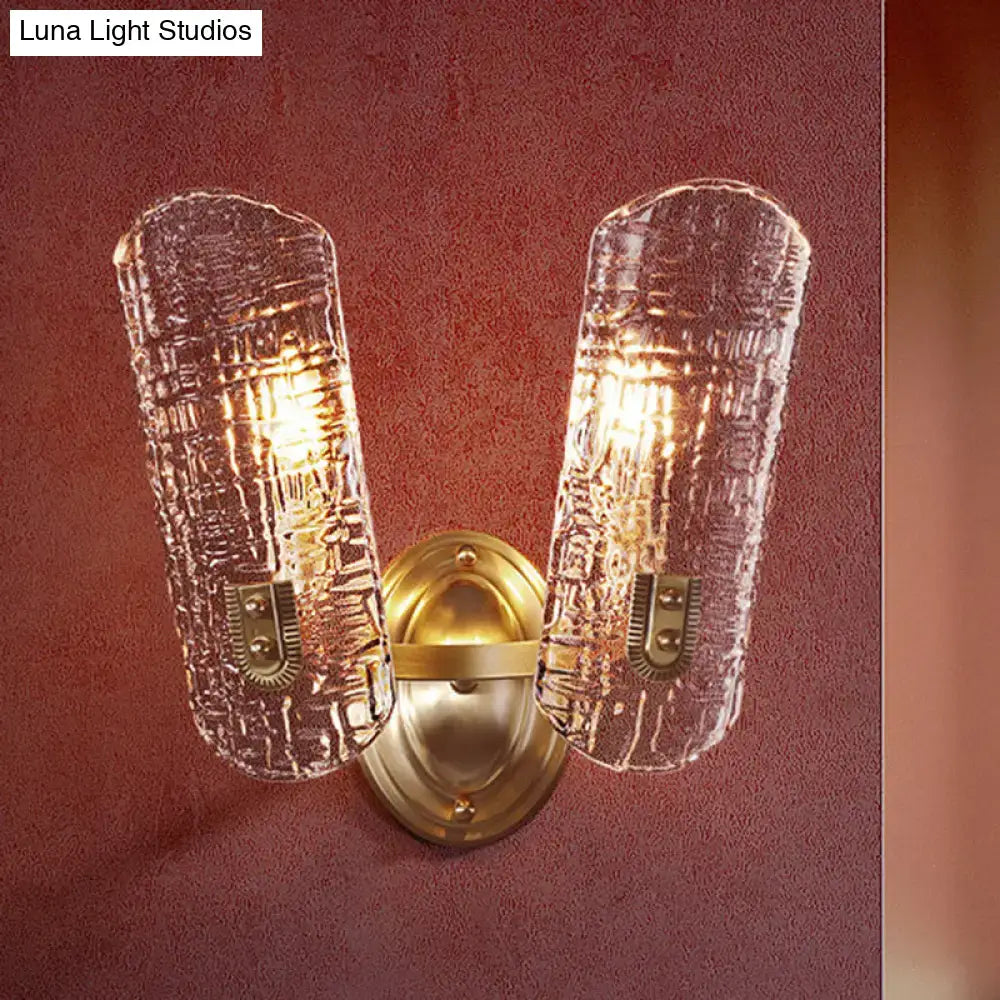 Brass-finished wall light with two clear textured glass shades designed for corridor lighting