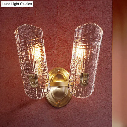 Brass-finished wall light with two clear textured glass shades designed for corridor lighting