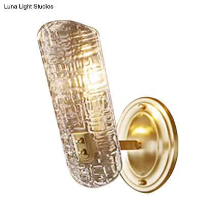 Gold-finished wall light featuring a textured clear glass shade designed for corridor lighting