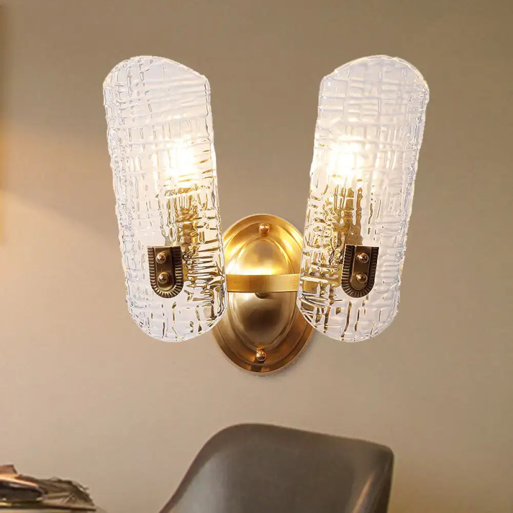 Gold-toned wall light with two clear textured prism glass shades featuring a subtle grid pattern for corridor use