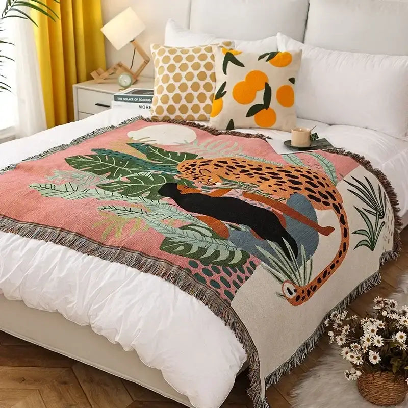 Cozy ethnic tapestry sofa blanket with vibrant leopards and lush green foliage on olive and pink woven fabric