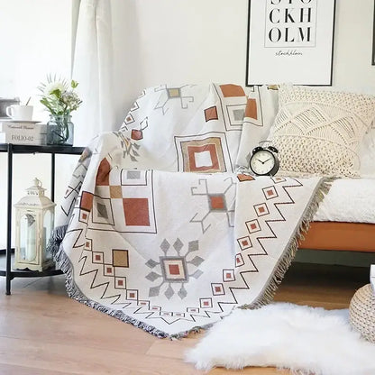 Off-white cozy ethnic tapestry sofa blanket with geometric rust gray beige pattern and fringed edges for living room