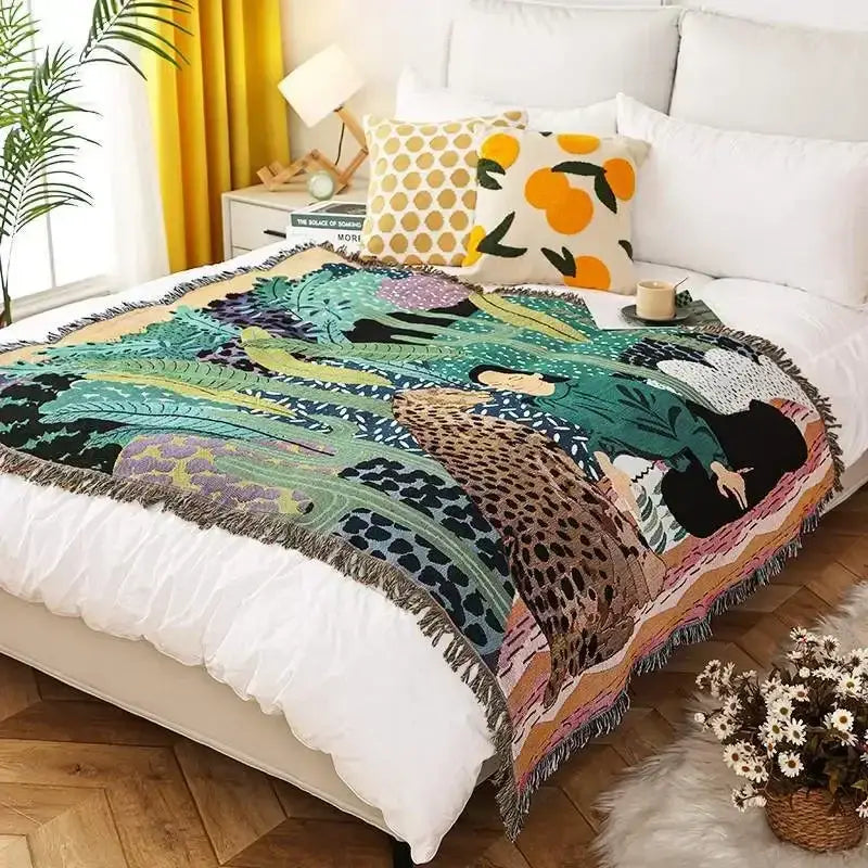 A vibrant ethnic tapestry sofa blanket with bold botanical and animal print in green, teal, brown, purple, and orange