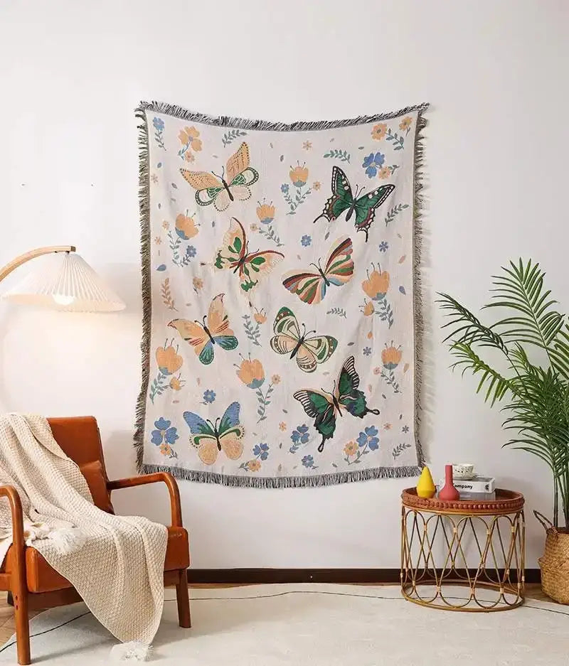 Cream-colored woven ethnic tapestry sofa blanket with vibrant multicolored butterflies and flowers with fringed edges