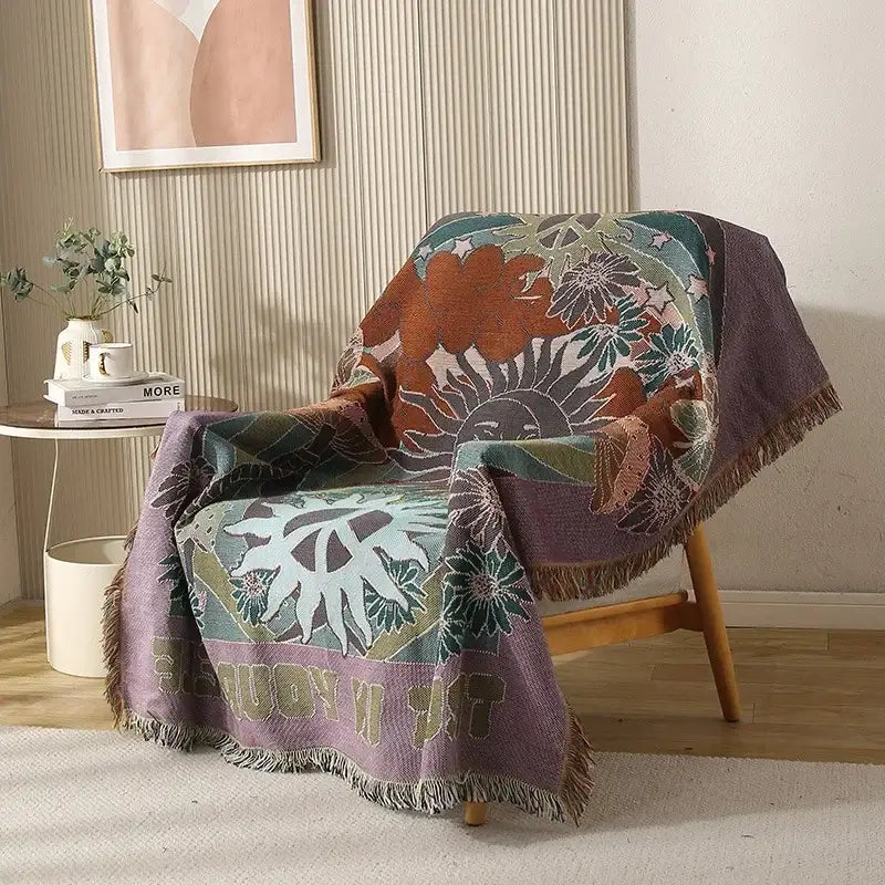 Cozy multicolored ethnic tapestry sofa blanket with vibrant floral sun motif and fringed edges in olive and pink tones
