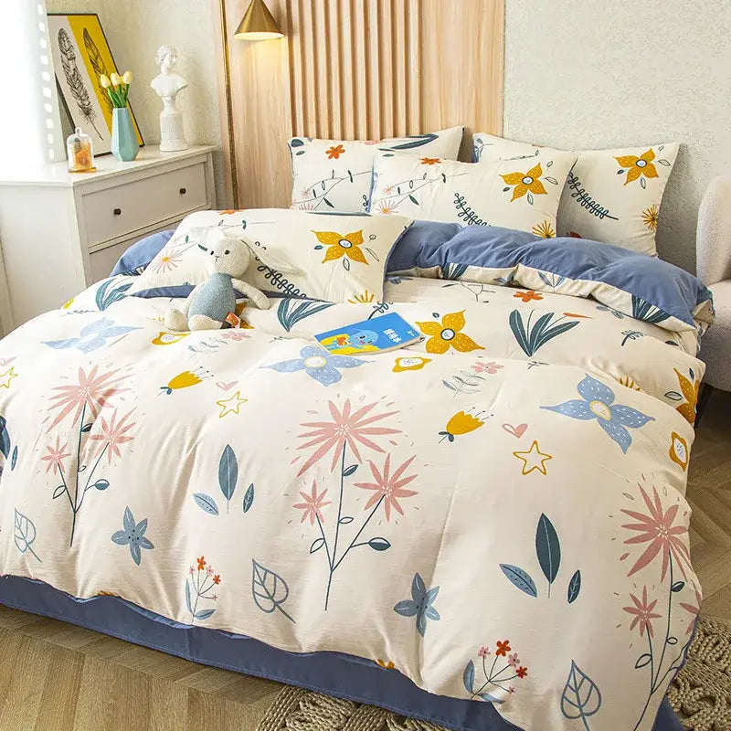 Cream-colored floral duvet cover with pink blue and yellow blossoms on cotton fabric in purple and blue leaf print bedding set