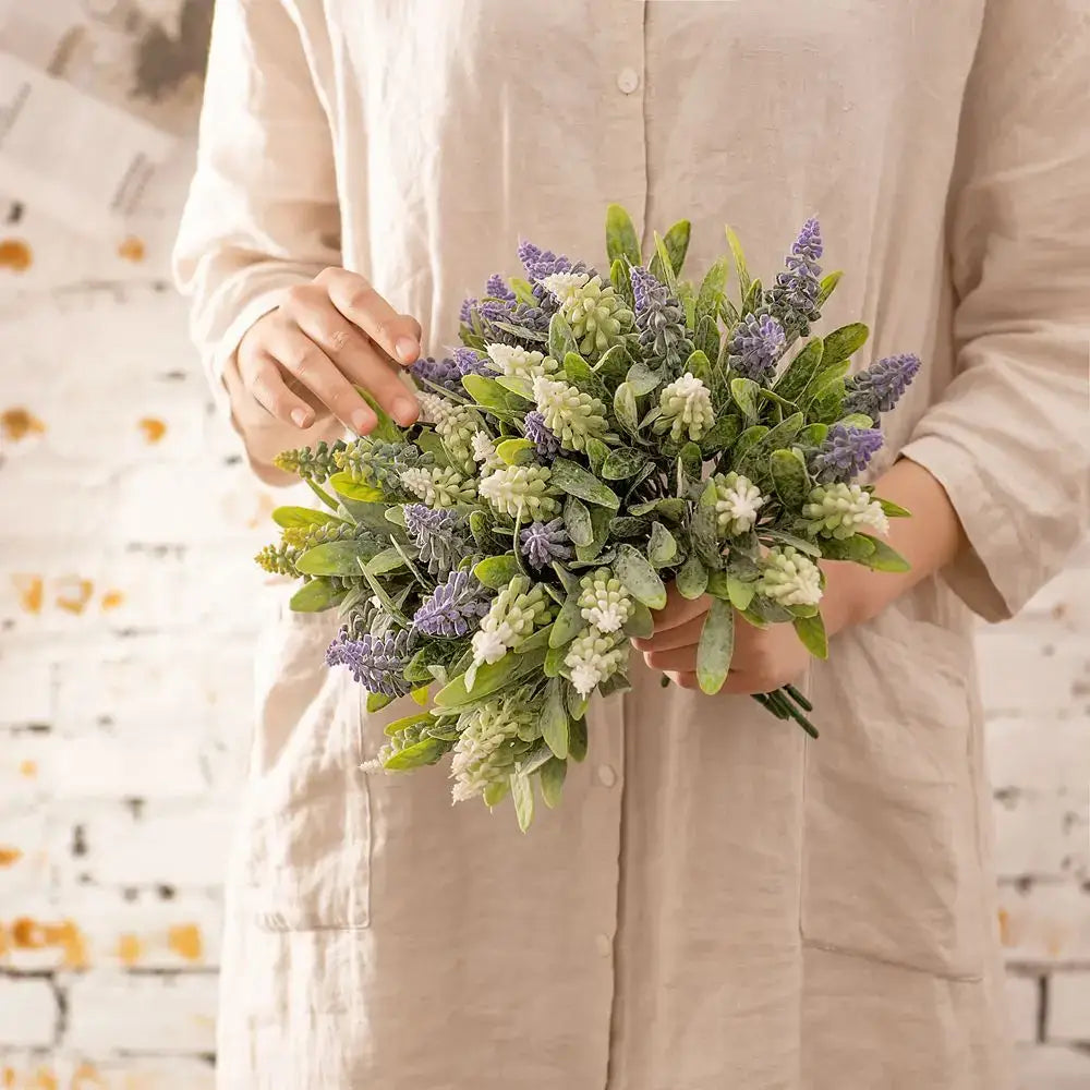 A delicate purple and white lavender fake green plants bouquet with frosted accents for wedding decor