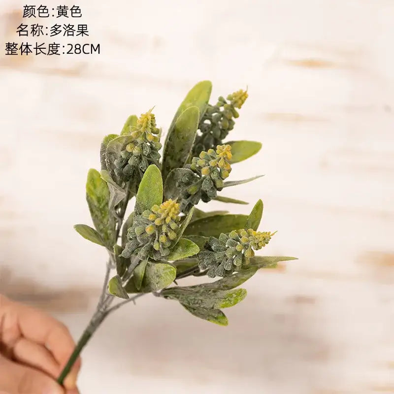 Artificial green and yellow boxwood branch with frosted leaves in a purple and white lavender fake green plants bouquet for wedding decor