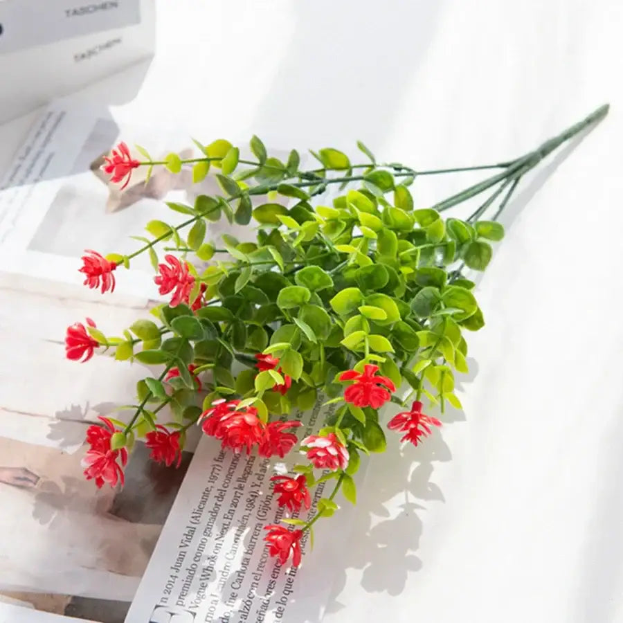 A vibrant red artificial eucalyptus plant with lush green leaves made from synthetic material for decorbites artificial use