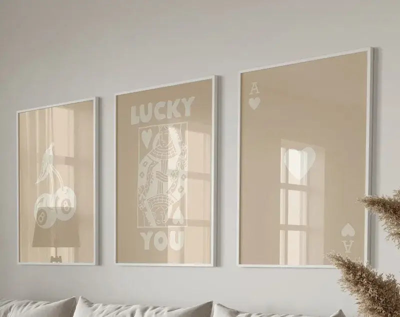 Set of three beige-framed wall art prints featuring minimalist white queen of hearts designs for hearts wall art decor